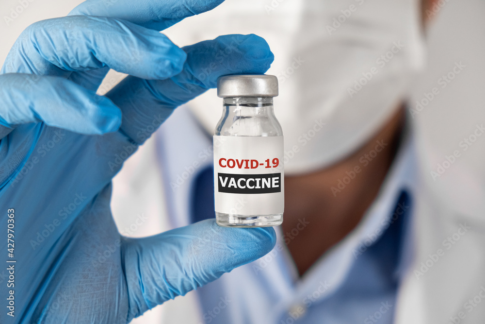 covid-19 coronavirus Vaccination concept in hand of doctor glass vaccine jar ampoule . White robe and gloves covid-19 coronavirus Vaccination concept in hand of doctor glass vaccine jar ampoule . White robe and gloves