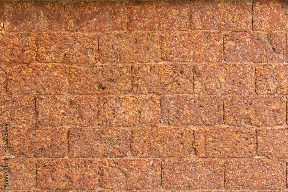 blur of red laterite brick wall Porous and fine-grained Background pattern blur of red laterite brick wall Porous and fine-grained Background pattern
