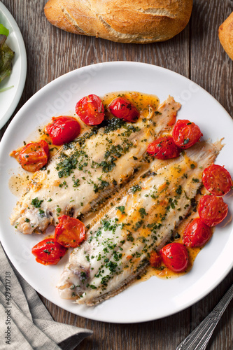 Sole with cherry tomatoes on a plate. High quality photo.