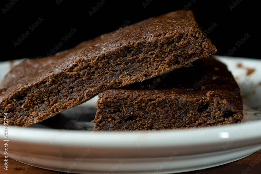 Brownie on white plate with black background