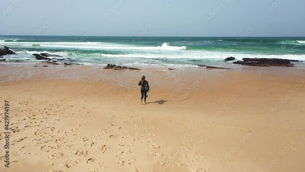 Girl is going to surf in Europe beach, Portugal