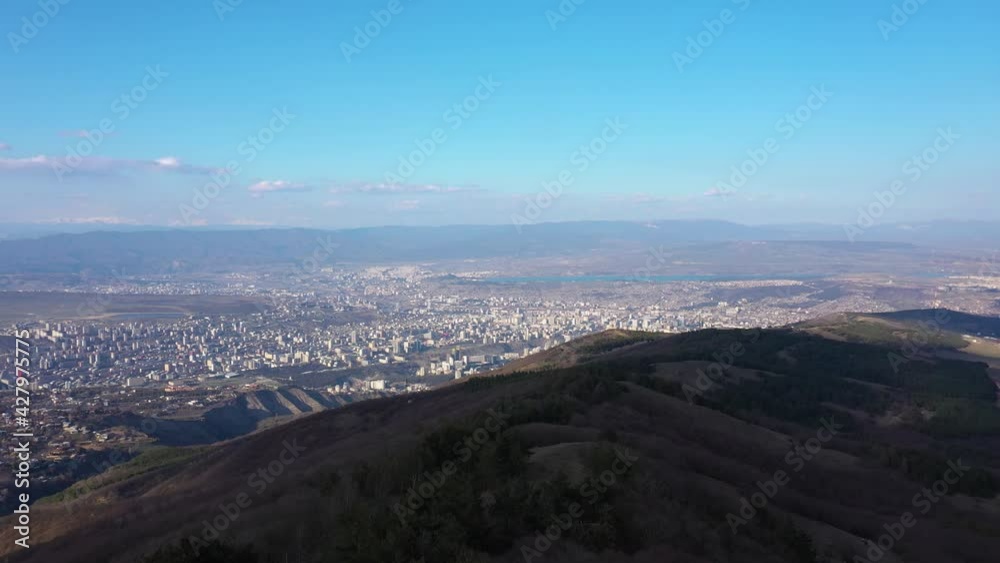 Aerial View Of Tbilisi City From A Mountain Under Bright Blue Sky At Daytime In Georgia. - wide, ascend Aerial View Of Tbilisi City From A Mountain Under Bright Blue Sky At Daytime In Georgia. - wide, ascend