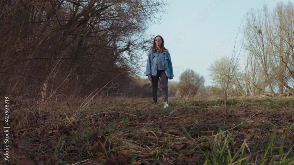 Girl walking through a clearence in a Forrest - Slowmotion Girl walking through a clearence in a Forrest - Slowmotion