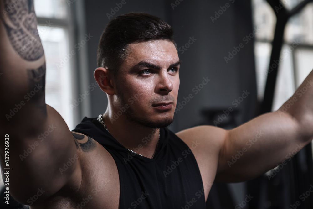 Close up of a handsome muscular male athlete looking focused in dramatic lighting Close up of a handsome muscular male athlete looking focused in dramatic lighting
