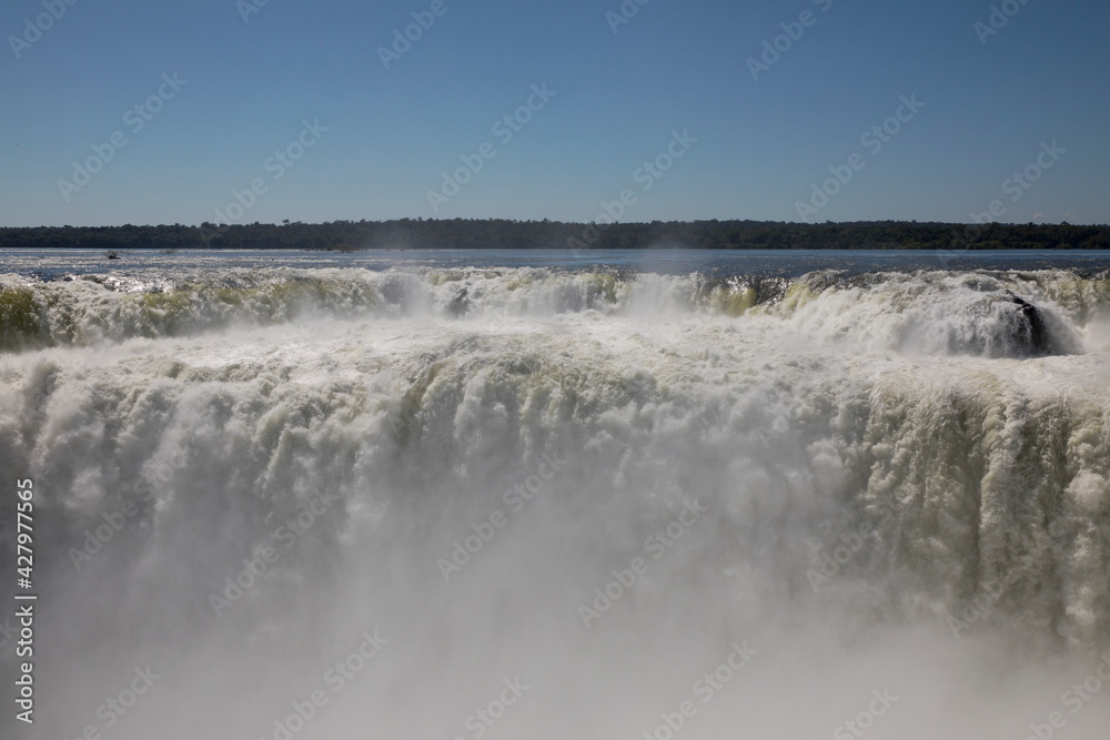 Nature's power. View of the Iguazu waterfalls and river, seen from Garganta del Diablo, in Misiones, Argentina. The amazing falls and falling white water beautiful texture, mist and splash.