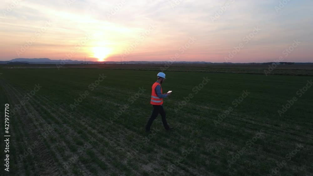 Slow Motion of Agricultural Engineer Checking Crop Progress, Adding Information Data in Tablet and Sending Them Over 5G Network. Futuristic Agriculture and Food Industry Concept Slow Motion of Agricultural Engineer Checking Crop Progress, Adding Information Data in Tablet and Sending Them Over 5G Network. Futuristic Agriculture and Food Industry Concept