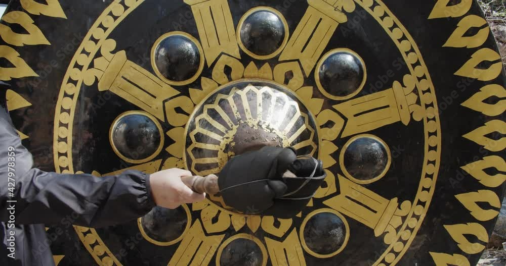 tourist person hitting Clangs a Giant oriental gong Bell at Thai temple