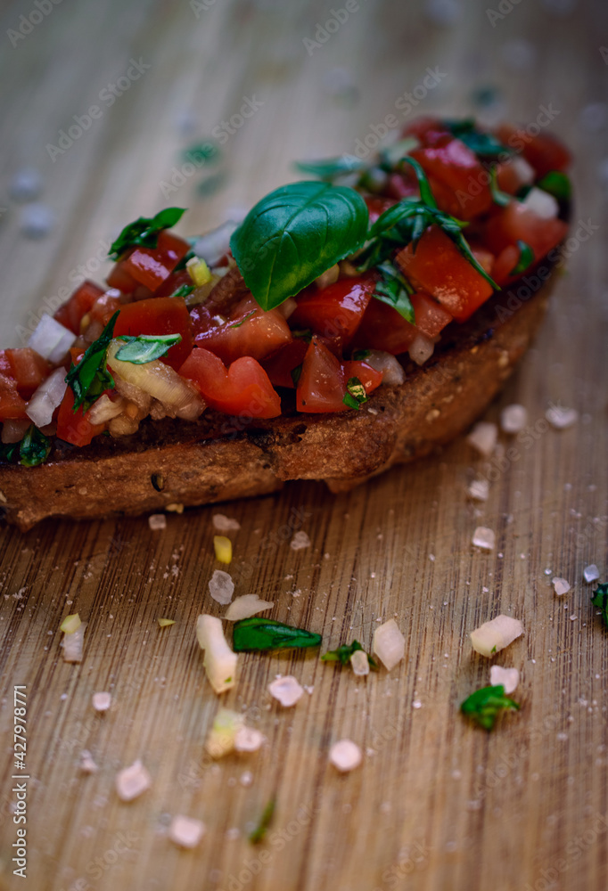 Bruschetta on a wooden board - fresh tomatoes, onions and basil on toasted bread Bruschetta on a wooden board - fresh tomatoes, onions and basil on toasted bread