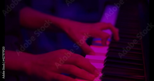 Close up of finger musician at the piano , The pianist playing  piano in the room ,classic piano,neon light,funny,hobby.