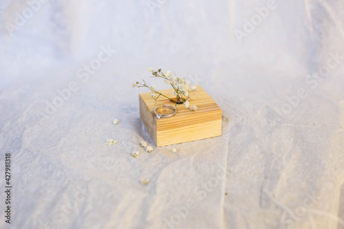 An engagement ring with a white gold stone lies on a stand