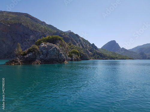 Seascape against the backdrop of mountains on a sunny, cloudless day.