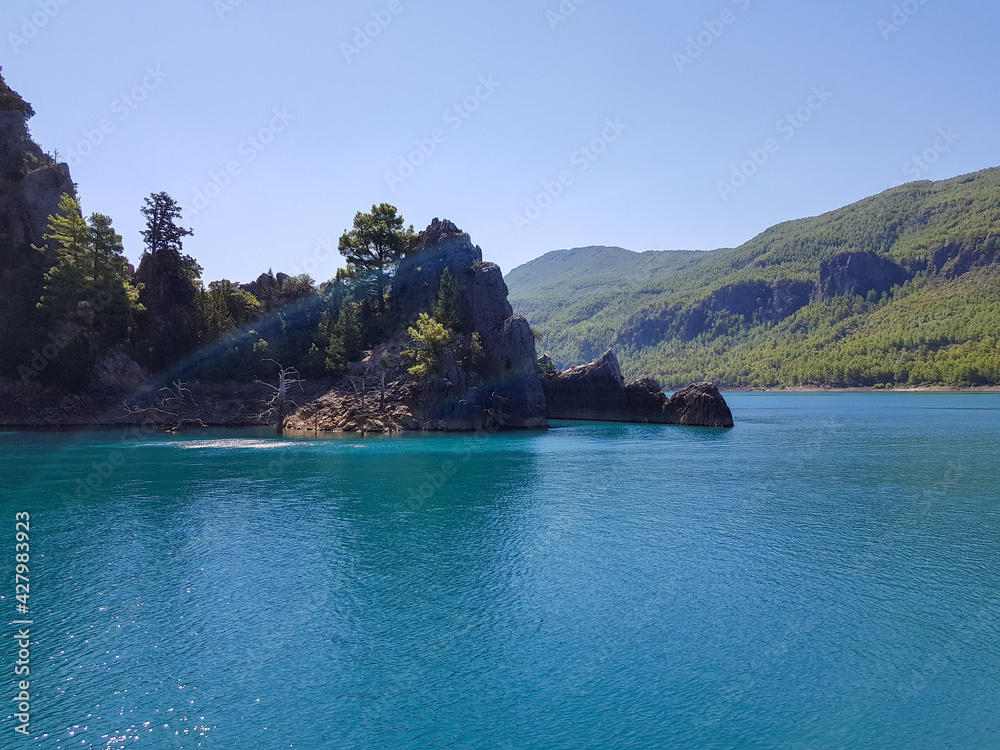Obraz premium Seascape against the backdrop of mountains on a cloudless sunny day.