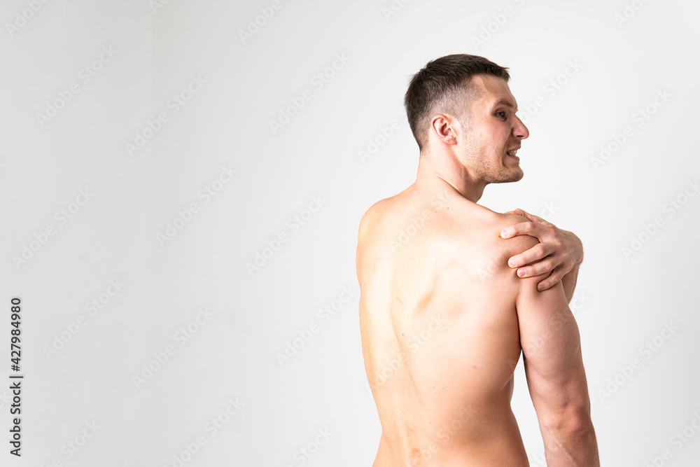 A sore shoulder joint muscle in a white man on a white background ache sore sick isolated massage medicine, hand chronic. Touching neck sickness, disease suffer attractive
