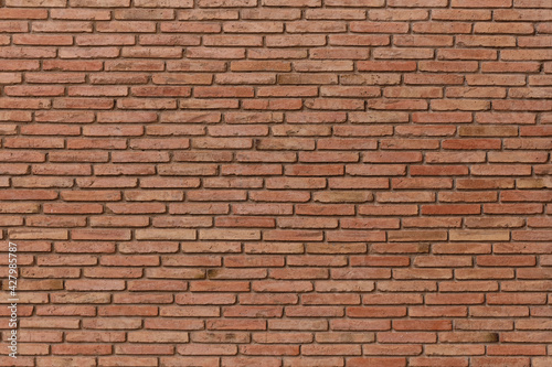 Red brick pattern. Old brick wall with cracks and scratches. Horizontal brick wall background. Vintage house facade.