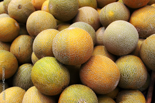 Yellow, juicy malons on the big counter of the market.