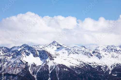 Winter landscape, snowcapped mountains with cloudscape, blue sky. Snowy mountain peaks in Swiss alps, Wallis. © MindestensM