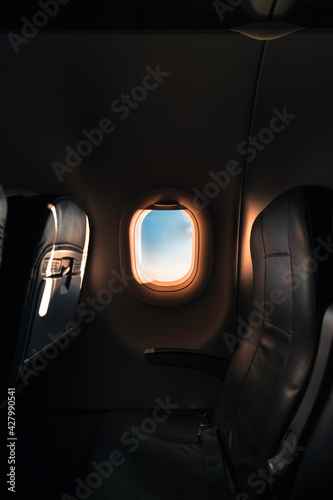Amanecer a través de una ventanilla desde el interior de un avión photo