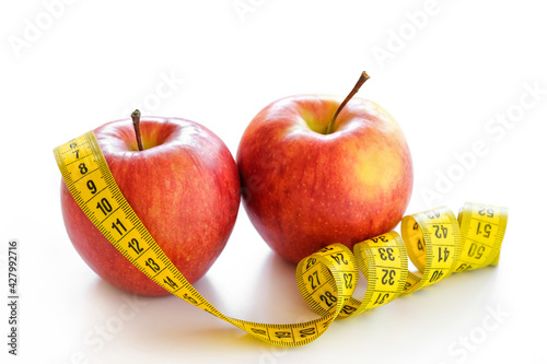 Red apples with measuring tape isolated on white. Healthy lifestyle, diet concept. Close-up