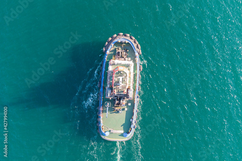 The sea tug moves from the port water area towards the open sea. Photo from the helicopter. View from above.