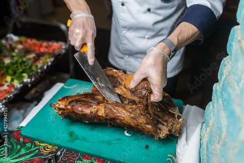 Chef cuts baked pork in a restaurant