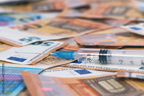 Close-up syringes and euros banknotes bills. Cost of health, medicine, drug concept
