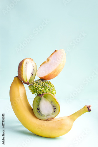 Fototapeta Naklejka Na Ścianę i Meble -  Fresh ripe vitamin vegan vegetables and fruits on table. Equilibrium floating food balance on green background, creative concept