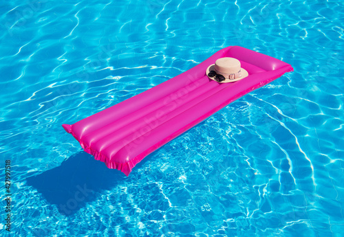 Beach summer holiday background. Inflatable air mattress and hat on swimming pool.;