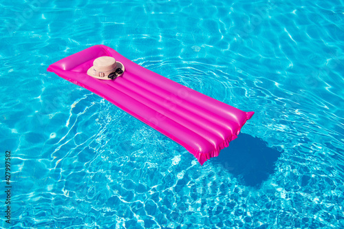 Beach summer holiday background. Inflatable air mattress and hat on swimming pool.  © nata777_7