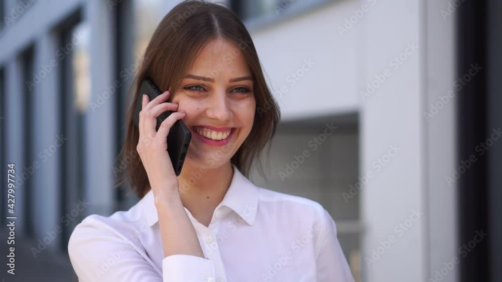 Smiling young girl talking on the mobile phone.Business woman answers phone call Smiling young girl talking on the mobile phone.Business woman answers phone call