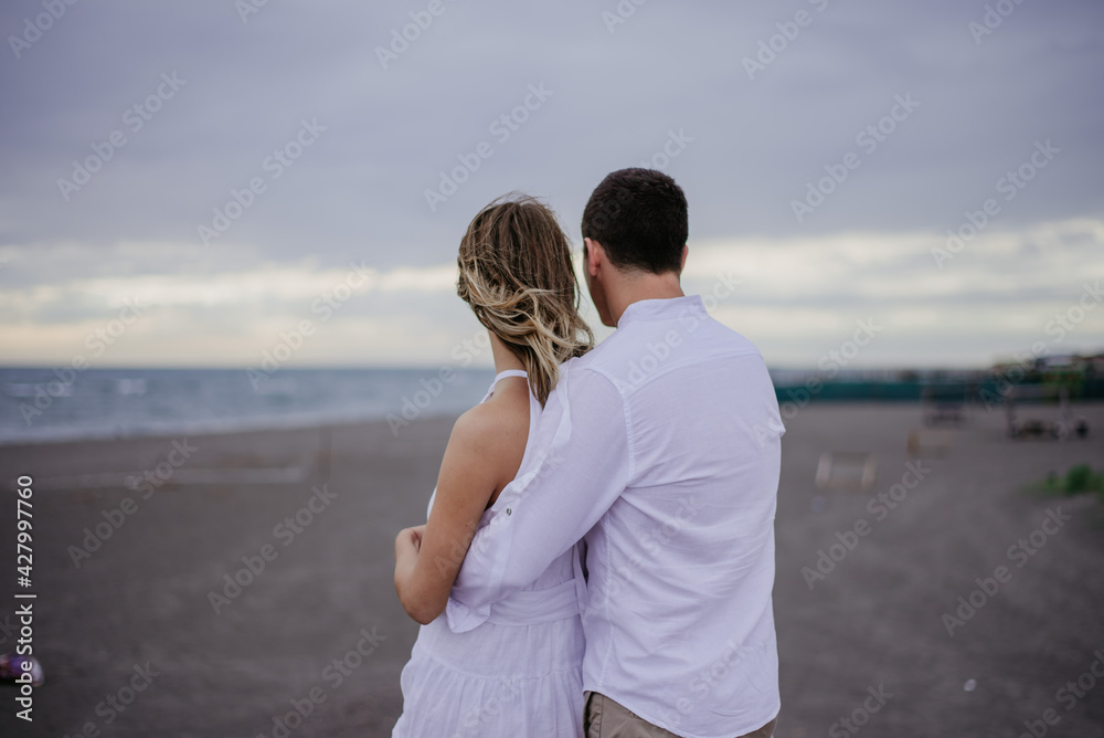 couple on the beach on their wedding day bride and groom watching sunset