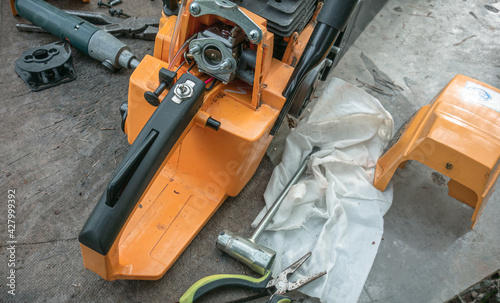 Wallpaper Mural Disassembled chainsaw on the table, next to the tool for repair Torontodigital.ca