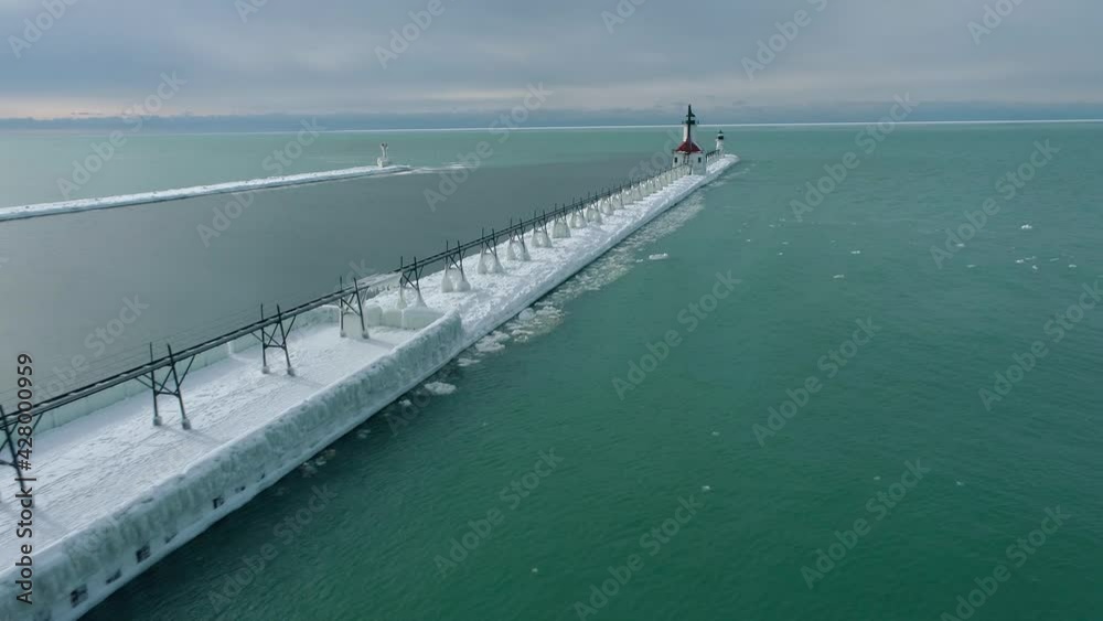 Aerial 4k shot of Frozen Lake Michigan Lighthouse and Pier. Location St. Joseph Michigan. Aerial 4k shot of Frozen Lake Michigan Lighthouse and Pier. Location St. Joseph Michigan.