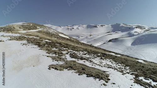 Sunny day with mountains covered by snow. Spring season in a Lebanese village. Middle east region. Best travel destination to enjoy the holidays. Vacation and tourism in Lebanon. Snow melting photo