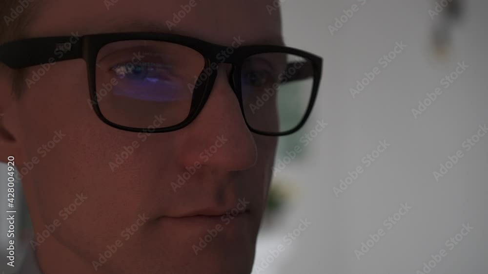 The programmer writes the program code. Reflection of the program code in glasses. The programmer writes the program code. Reflection of the program code in glasses.