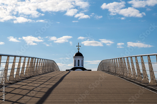 White Orthodox church and bridge on a bright sunny day against a blue sky