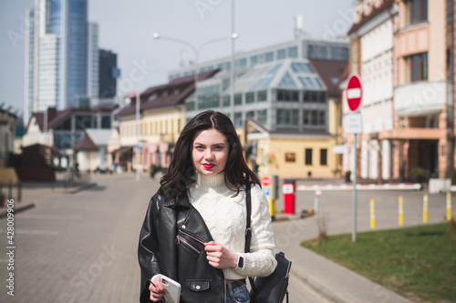 Beautiful young girl student hipster walks along the street of her city © bisonov