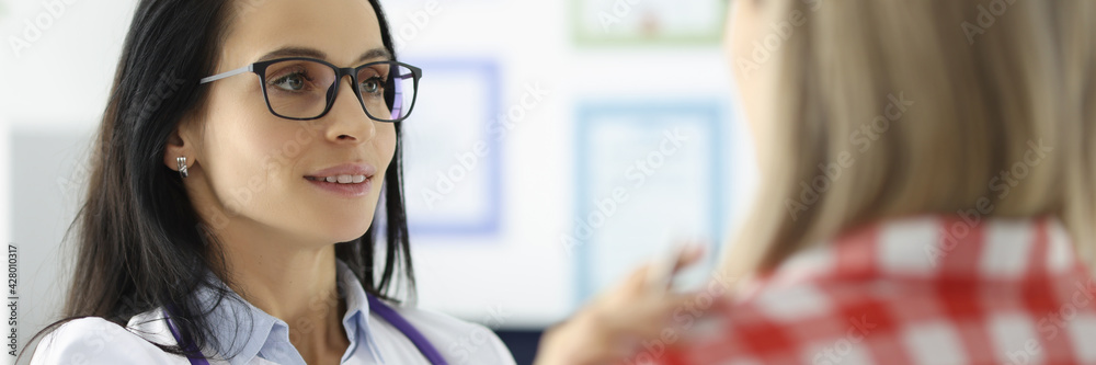 Young female doctor holding patient by shoulder in clinic Young female doctor holding patient by shoulder in clinic