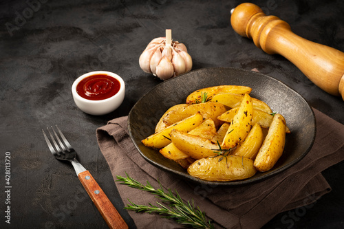 Roasted potatoes with rosemary on the plate. photo