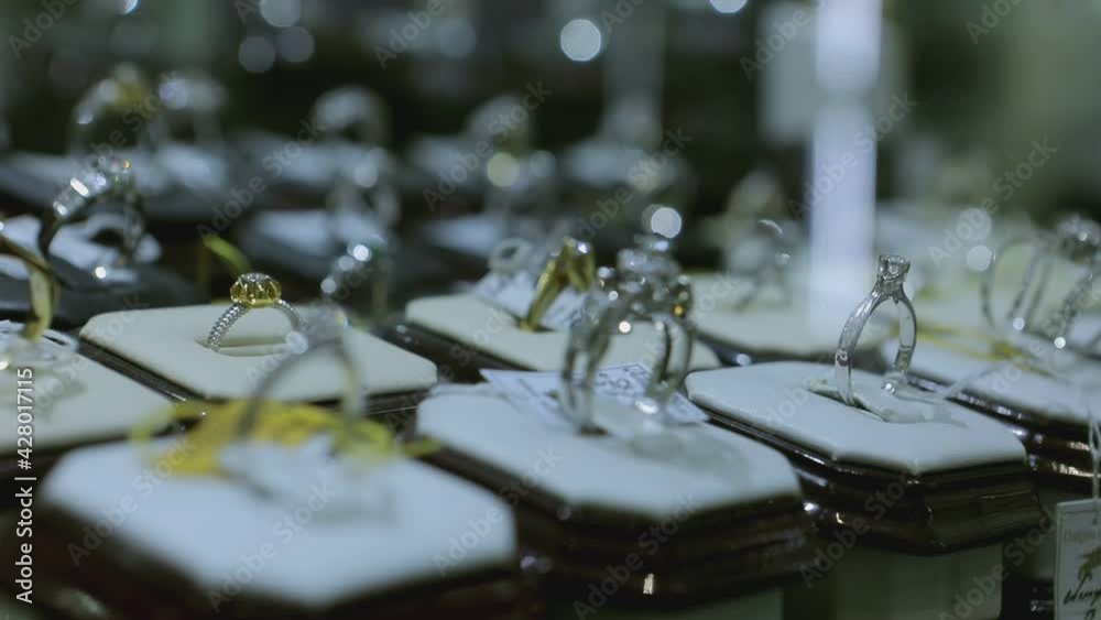 Expensive jewelry on the counter of a jewellery store . Various diamonds sapphires gold earrings bracelets , rings , necklaces with price tags . Beautiful bijouterie on shelves and mannequins Expensive jewelry on the counter of a jewellery store . Various diamonds sapphires gold earrings bracelets , rings , necklaces with price tags . Beautiful bijouterie on shelves and mannequins