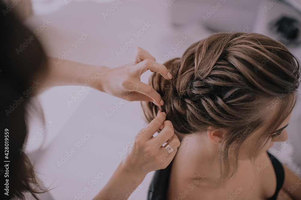 Fototapeta premium gathering of the bride, hands of the hairdresser and the bride's hairstyle close-up