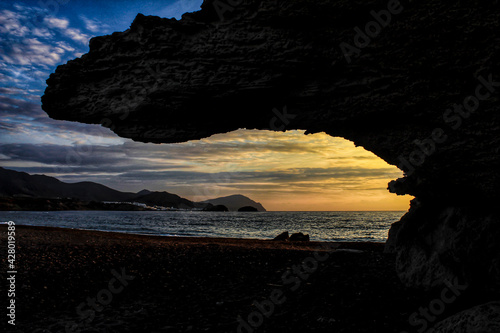 Sunrise on the beach and rock silhouettes