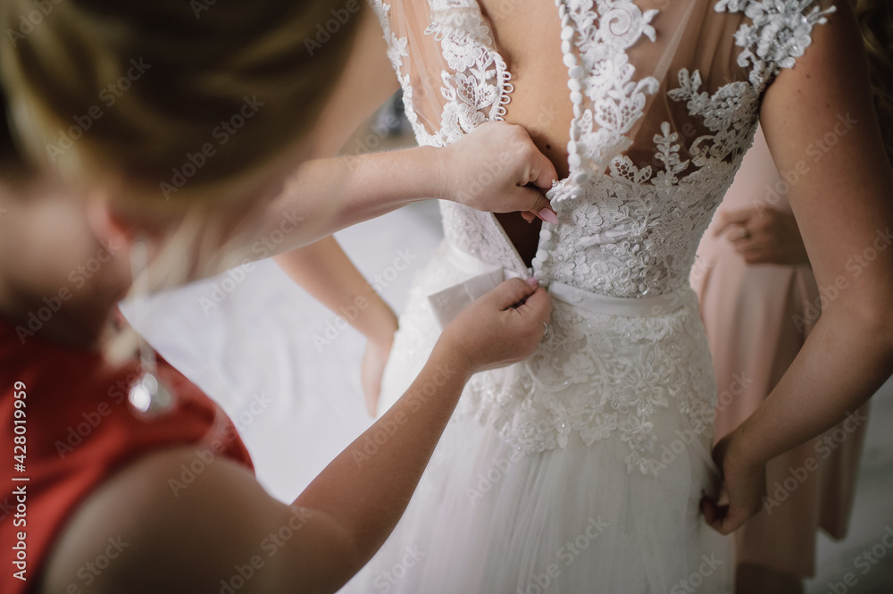 gathering of the bride, buttoning up a wedding dress close-up, buttons and woman's hands, an unbuttoned dress gathering of the bride, buttoning up a wedding dress close-up, buttons and woman's hands, an unbuttoned dress