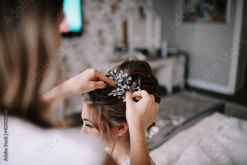 gathering of the bride, hands of the hairdresser and the bride's hairstyle close-up
