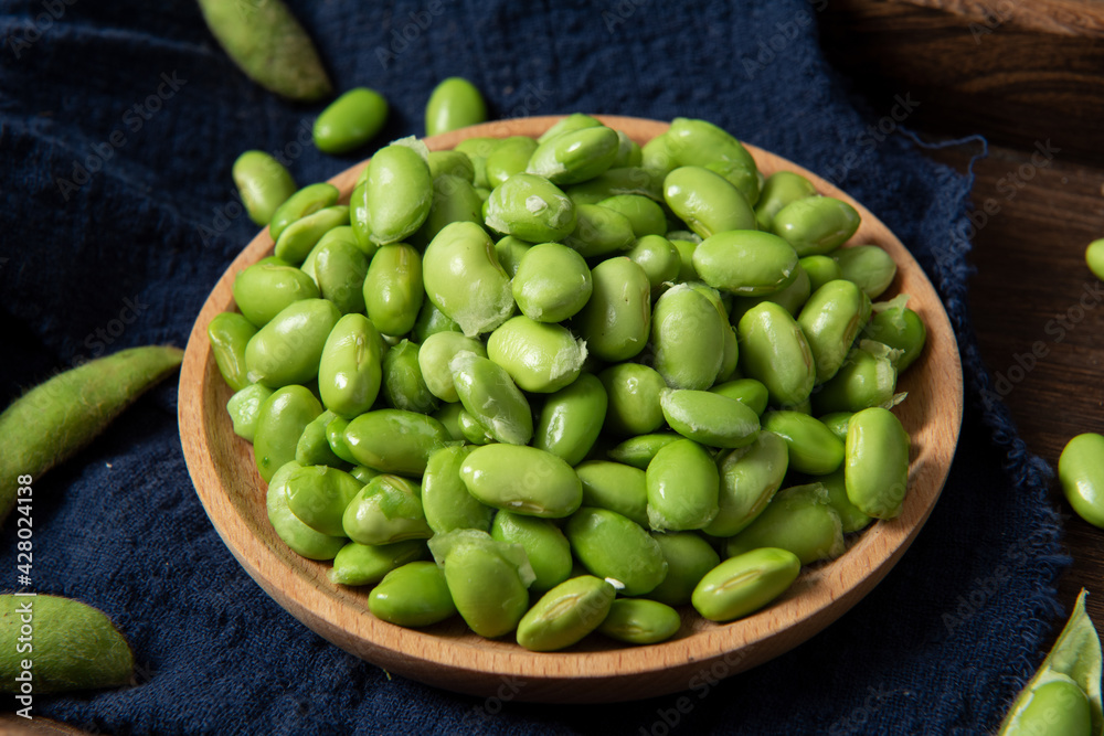 raw green soybean in plate on wooden background. fresh beans. raw green soybean in plate on wooden background. fresh beans.