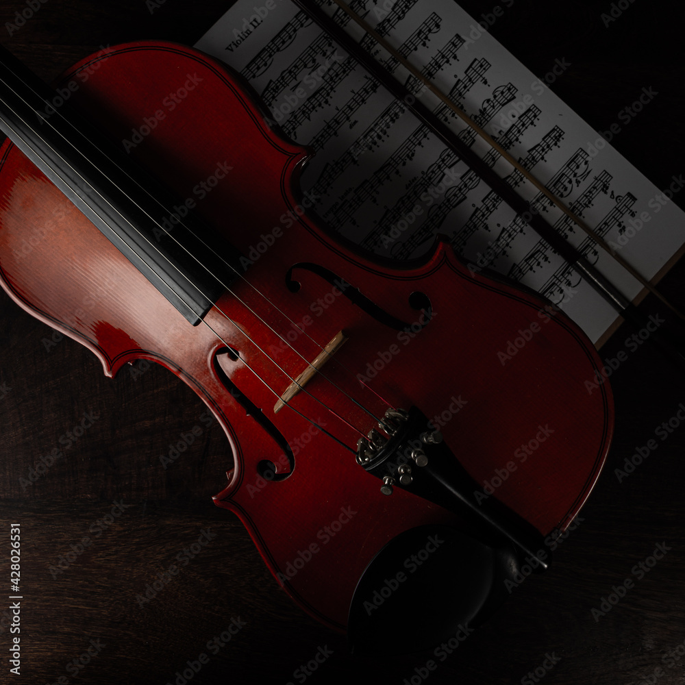 Fototapeta premium Composición de violín y arco sobre partitura 