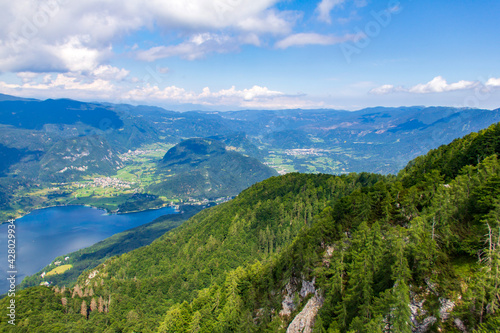 Sunny view over Slovenian mountains from high Vogel mountain near cable railway of Vogel Ski Center in summer day. Bohinj valley with lake from top.