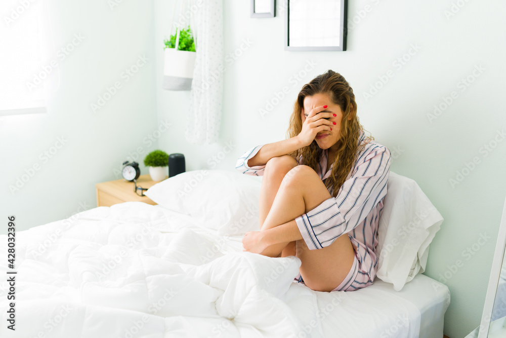 Beautiful woman sobbing and feeling sad in her bedroom Beautiful woman sobbing and feeling sad in her bedroom