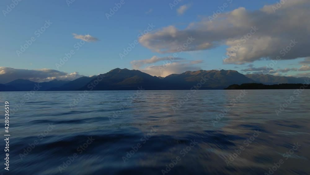 Flying above water surface on Lake Te Anau with mountains in the background Flying above water surface on Lake Te Anau with mountains in the background