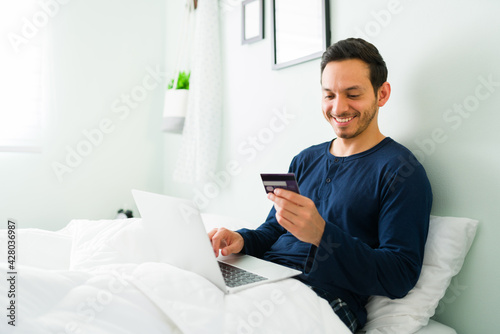 Happy man buying online with a credit card