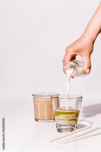 Pouring milk in matcha tea drink photo